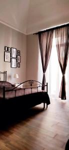 塔兰托Casa Principe Taranto "Intero appartamento"的一间卧室配有床和带窗帘的窗户