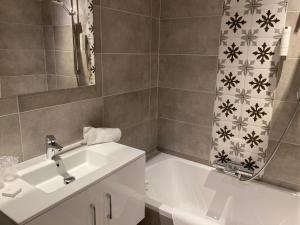 洛布奥特桑布尔酒店的一间带水槽、浴缸和淋浴的浴室