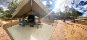 法尔瓦特Limpopo Bushveld Retreat的房屋设有1个带桌椅的大型帐篷