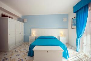 费拉约港圣乔瓦尼别墅酒店的蓝色卧室,配有一张带蓝色毯子的床