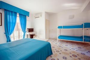 费拉约港圣乔瓦尼别墅酒店的一间卧室设有蓝色的床和窗户。