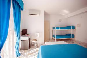 费拉约港圣乔瓦尼别墅酒店的一间卧室配有蓝色的床和一张书桌