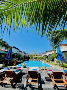高兰YinDee Lanta Villas的一个带躺椅和遮阳伞的游泳池