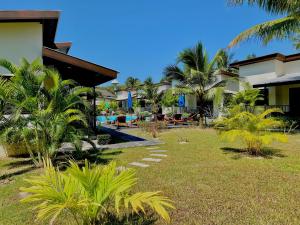 高兰YinDee Lanta Villas的棕榈树和游泳池的度假庭院