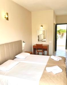 卡沃斯Oasis Beach Club的一间卧室配有两张床、一张桌子和一面镜子