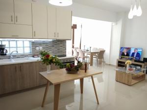 帕诺尔莫斯雷斯蒙Stylish home - comfortable holidays near the beach.的厨房配有白色橱柜和鲜花桌