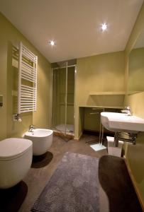奥斯塔城市之心公寓的浴室配有卫生间、盥洗盆和浴缸。
