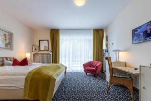 巴德索登陶努斯Thermen Hotel & Restaurant Bad Soden的配有一张床和一张书桌的酒店客房