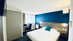 佩罗讷Hôtel Restaurant Kyriad de Péronne的酒店客房设有白色的床和蓝色的墙壁。