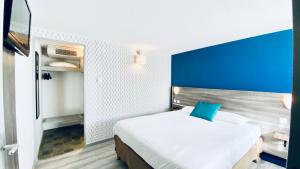 佩罗讷Hôtel Restaurant Kyriad de Péronne的一间卧室配有一张大床和蓝色床头板