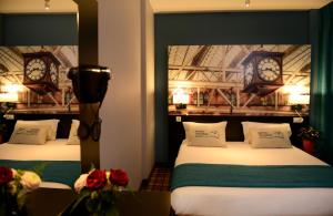 里昂维多利亚里昂佩拉什酒店的墙上挂有时钟的房间里设有两张床