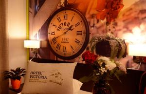 里昂维多利亚里昂佩拉什酒店的枕头旁边的墙上挂着一个钟