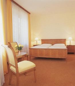 维也纳维也纳河畔酒店的一间卧室配有一张床、一把椅子和一张桌子