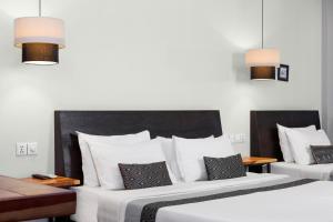贡布菲弗.S酒店的配有白色枕头的酒店客房内的两张床