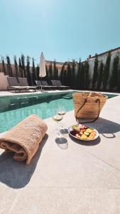 阿瑞安妮Ynaira hotel & Spa的游泳池旁的果盘和酒杯