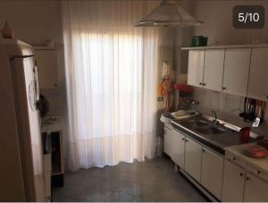 诺托Apartment in Noto 38244的带水槽的厨房和带窗帘的窗户