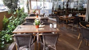 伊斯坦布尔Payidar HOTEL的餐厅设有木桌和椅子,种有植物