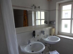 吕本瑙劳奇兹霍夫旅馆的浴室设有2个水槽、镜子和窗户。