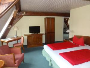 吕本瑙劳奇兹霍夫旅馆的一间卧室配有一张床、一张书桌和一台电视