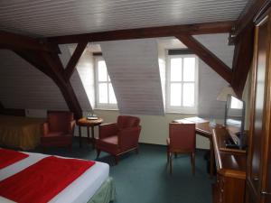 吕本瑙劳奇兹霍夫旅馆的卧室配有一张床、一张桌子和椅子
