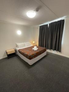 墨尔本Parkside Inn Motel的一间卧室设有一张大床和一个窗户。