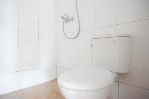 梭罗RedDoorz Syariah near UMS Solo的白色的浴室设有卫生间和淋浴。