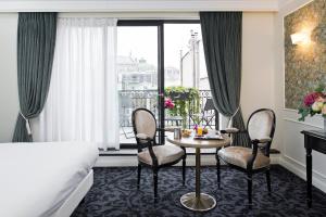 巴黎Hôtel Saint-Pétersbourg Opéra & Spa的酒店客房配有桌椅和一张床