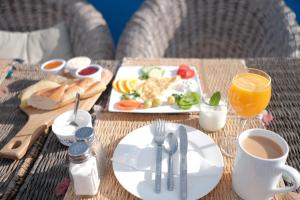 舍夫沙万达尔艾尔里奥住宿加早餐旅馆的餐桌,上面放着一盘食物和一杯橙汁