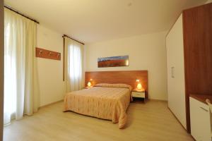 圣米凯莱亚尔塔利亚门托Terzo Bacino的一间卧室配有一张床和一张桌子上的两盏灯。