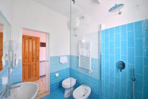 伊斯基亚欧洲大酒店 的蓝色瓷砖浴室设有卫生间和水槽