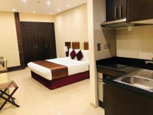 迪拜The View Al Barsha Hotel Apartments的酒店客房带一张床和一个厨房