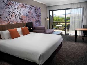 罗兰低地诺富特巴罗莎谷度假酒店的一间带大床的卧室和一间客厅
