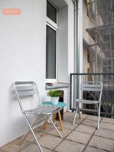 柏林Apartment Berlin Lottumstraße的阳台配有2把椅子和1张桌子