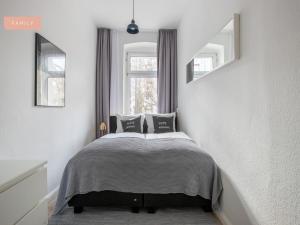 柏林Apartment Berlin Lottumstraße的一间卧室设有一张床和两个窗户。
