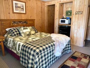 圣伊尼亚斯Moosewood Inn的一间卧室配有一张带 ⁇ 子毯子的床