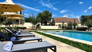 Saint-Jean-de-TrézyDomaine de Rymska & Spa - Relais & Châteaux的游泳池旁一排带遮阳伞的躺椅