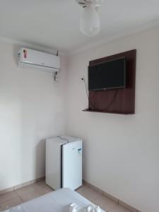 卡达斯诺瓦斯Pousada 4 Estações的客房设有冰箱和平面电视。