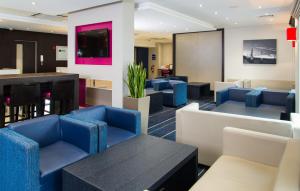 伦敦伦敦-旺兹沃思智选假日酒店的一间设有蓝色椅子和桌子的等候室