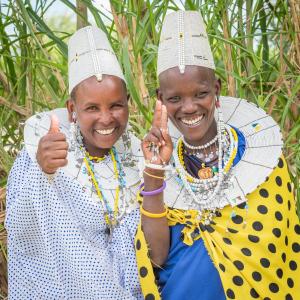 MtowabagaLake Natron Maasai giraffe eco Lodge and camping的两个年纪较大的女人给大 ⁇ 指签
