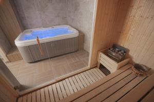 科帕奥尼克Belvedere Hills Luxury Apartments and Spa的一间蓝色浴缸的小桑拿浴室