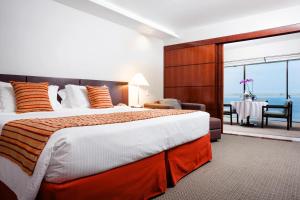 里约热内卢里奥安托宫殿酒店的一间卧室设有一张大床,享有海景