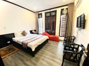 Thái BìnhKhách sạn Hoàng Gia的一间卧室配有一张床、一台电视和一把椅子