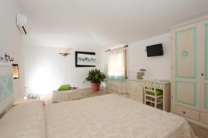 多尔加利Residenza di Campagna Seranile的一间卧室配有两张床、一张桌子和一台电视。