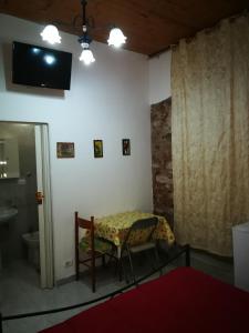 卡塔尼亚Casa del vico的客房设有桌子、电视和浴室。