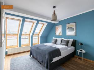 柏林Apartment Berlin Am Friedrichshain的卧室拥有蓝色的墙壁,设有一张床和窗户。