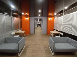 叶卡捷琳堡ОТЕЛЬ СОН lite的一间配有沙发、桌子和橙色墙壁的等候室