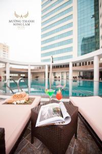 荣市孟清宋林奢华酒店的阳台配有桌子、饮料和书籍