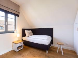 德兰斯克Reetland am Meer - Premium Reetdachvilla mit 2 Schlafzimmern, Sauna und Kamin E04的一间小卧室,配有床和窗户