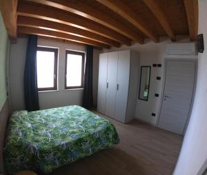 明乔河畔蓬蒂Agriturismo Ai Tre Fienili的一间卧室设有一张床和一个窗口