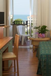卡托利卡Hotel President的客房设有书桌、桌子和阳台。